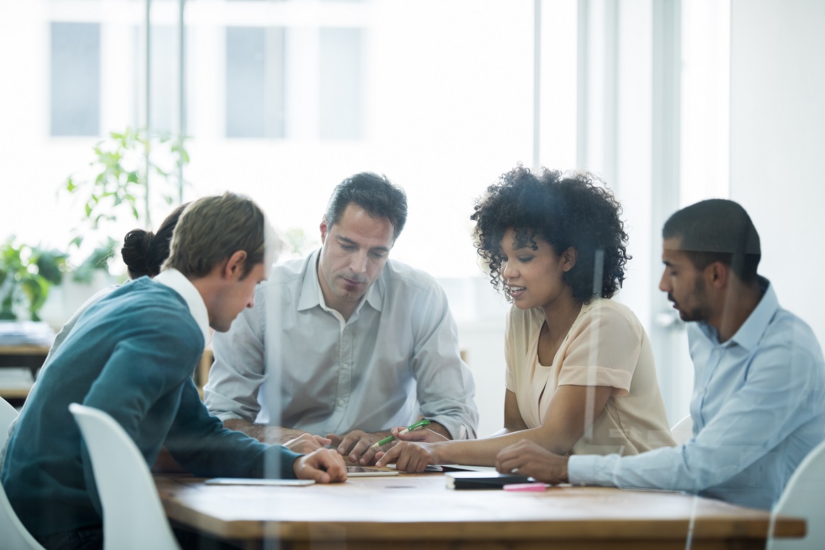 A group of business people putting their heads together.