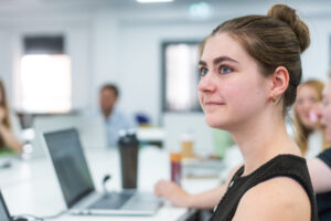Female marketing executive apprentice sitting in a classroom with a computer
